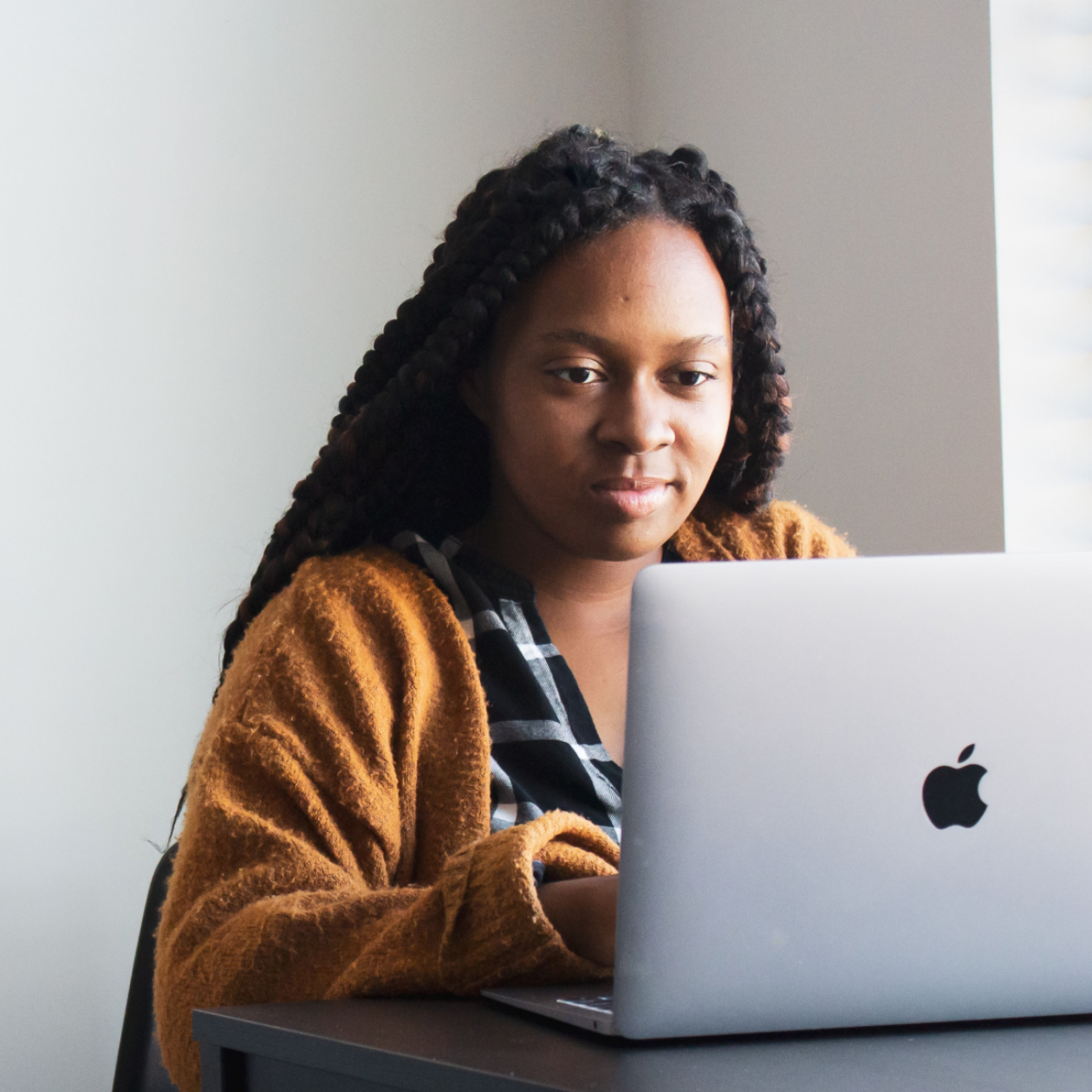 A person sitting at a desk using a laptop.